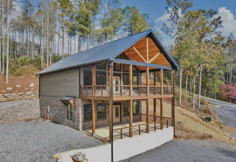 Nowoczesny dom szkieletowy z metalowym dachem i dużymi tarasami.