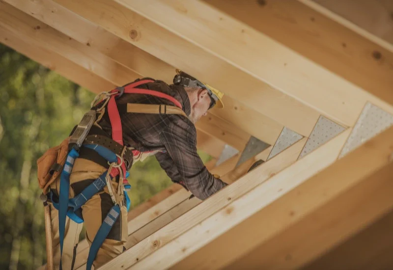 Doświadczony cieśla pracujący przy montażu więźby dachowej