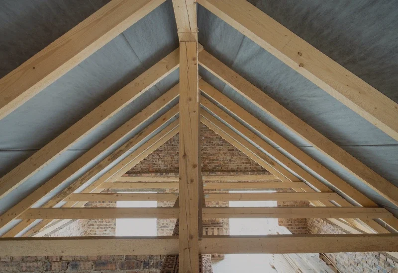 Solidna drewniana więźba dachowa - profesjonalne usługi ciesielskie.