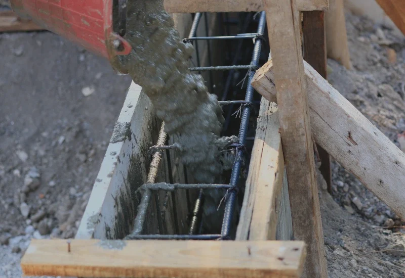 Wylewanie betonu do zbrojonych ław fundamentowych - roboty żelbetowe.